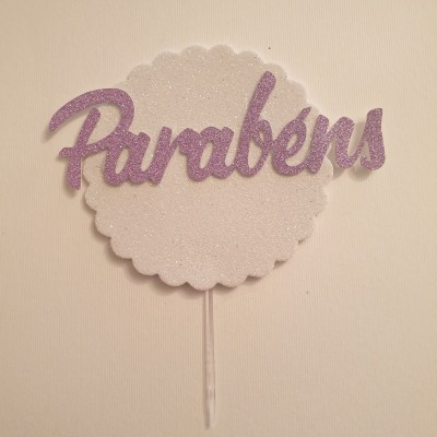 Decoração de bolo branca circular com texto 'Parabéns' em glitter lilás