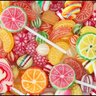 Variedade de rebuçados e pirulitos coloridos com padrões de frutas e listras