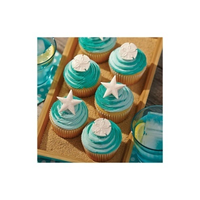 Cupcakes com cobertura azul e decoração de estrela do mar e conchas numa bandeja de madeira