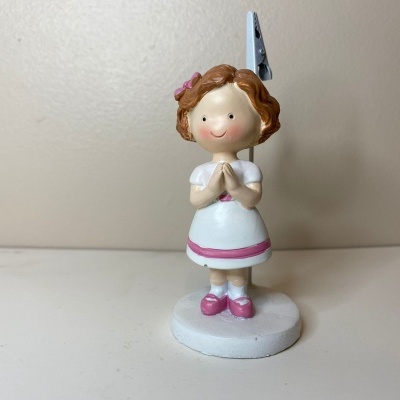 Figura decorativa de menina em vestido branco e rosa com cabelo castanho.