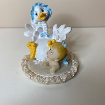 Figura decorativa de bebé e cisne sobre base texturada