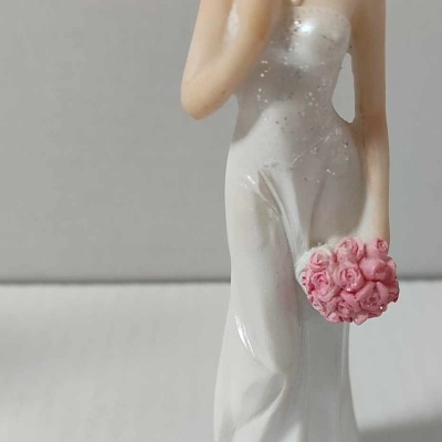 Figurinha decorativa de noiva com vestido branco e bouquet rosa