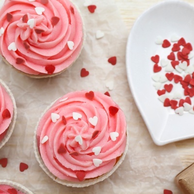Cupcakes com cobertura rosa e confeitos em forma de coração