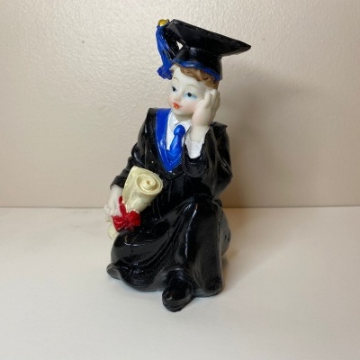 Figura decorativa de porcelana de formatura com chapéu azul e preto e diploma