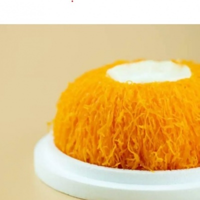 Esponja de banho laranja com branco em prato branco