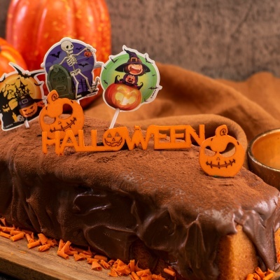 Bolo decorado com enfeites de Halloween coloridos e creme de chocolate