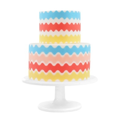 Bolo colorido de dois andares com padrão de ondas em suporte branco