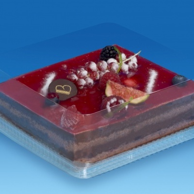 Bolo quadrado com camadas de chocolate e cobertura vermelha com frutas e placa de chocolate