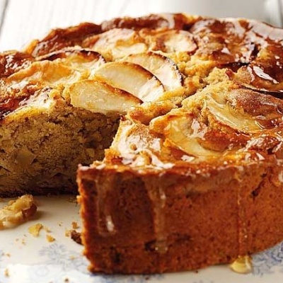 Bolo de maçã caseiro com fatia cortada num prato branco com padrão azul