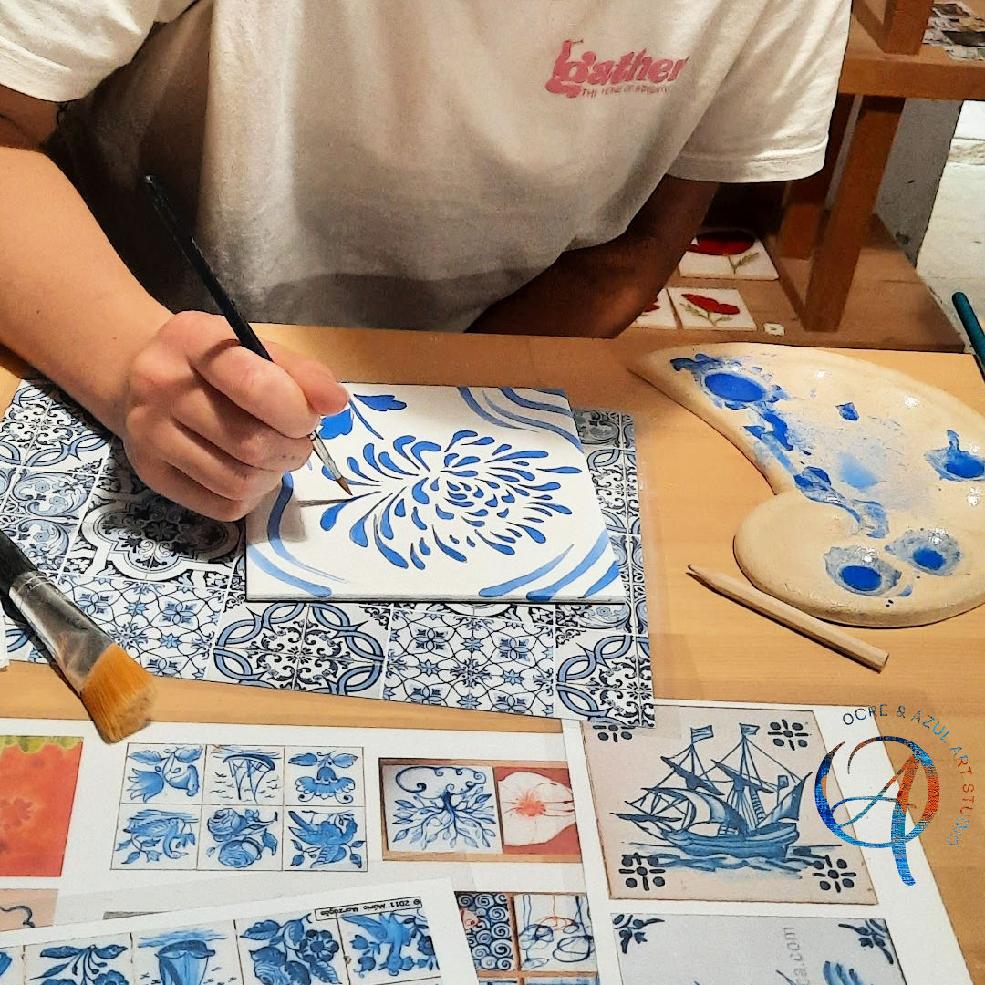 Tile Painting Workshop Pessoa pintando azulejo branco com padrão azul floral à mão