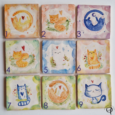 Nove azulejos quadrados com desenhos coloridos de gatos e corações, numerados e com bordas coloridas.