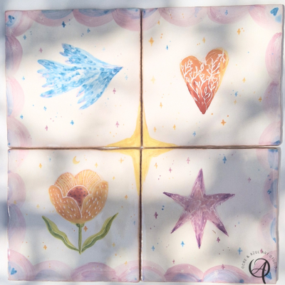 Conjunto de quatro azulejos cerâmicos decorados com desenho de asa azul, coração vermelho, flor amarela e estrela roxa