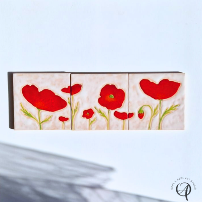 Três azulejos decorativos com papoilas vermelhas em fundo claro.