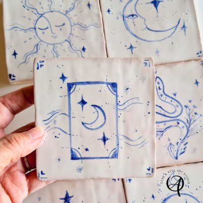 Azulejos de cerâmica em branco com desenhos azuis de lua, estrelas e outras figuras