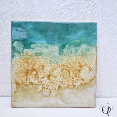 Azulejo cerâmico quadrado com padrão azul, verde, amarelo e bege que lembra mar e areia