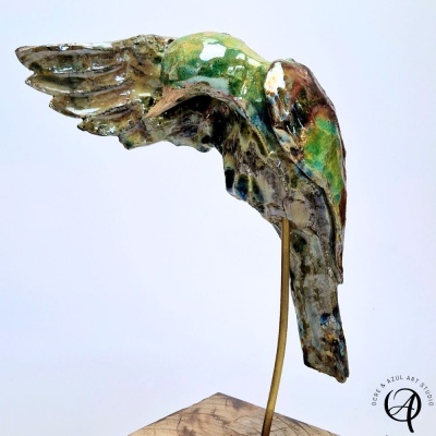Escultura cerâmica de pássaro colorido em suporte metálico com base de madeira