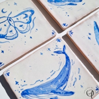 Azulejos de cerâmica branca com desenhos azuis de animais e elementos celestiais