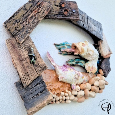 Peça decorativa de parede com madeira envelhecida e peixes em cerâmica colorida