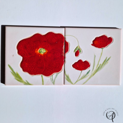 Dois azulejos cerâmicos com flores vermelhas e detalhes verdes em fundo branco
