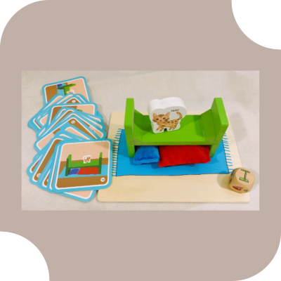 Jogo de cartas e peças de madeira com cama verde e gato ilustrado.