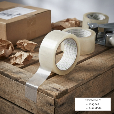 Fita adesiva transparente, caixa de cartão e pedaços de papel sobre mesa de madeira