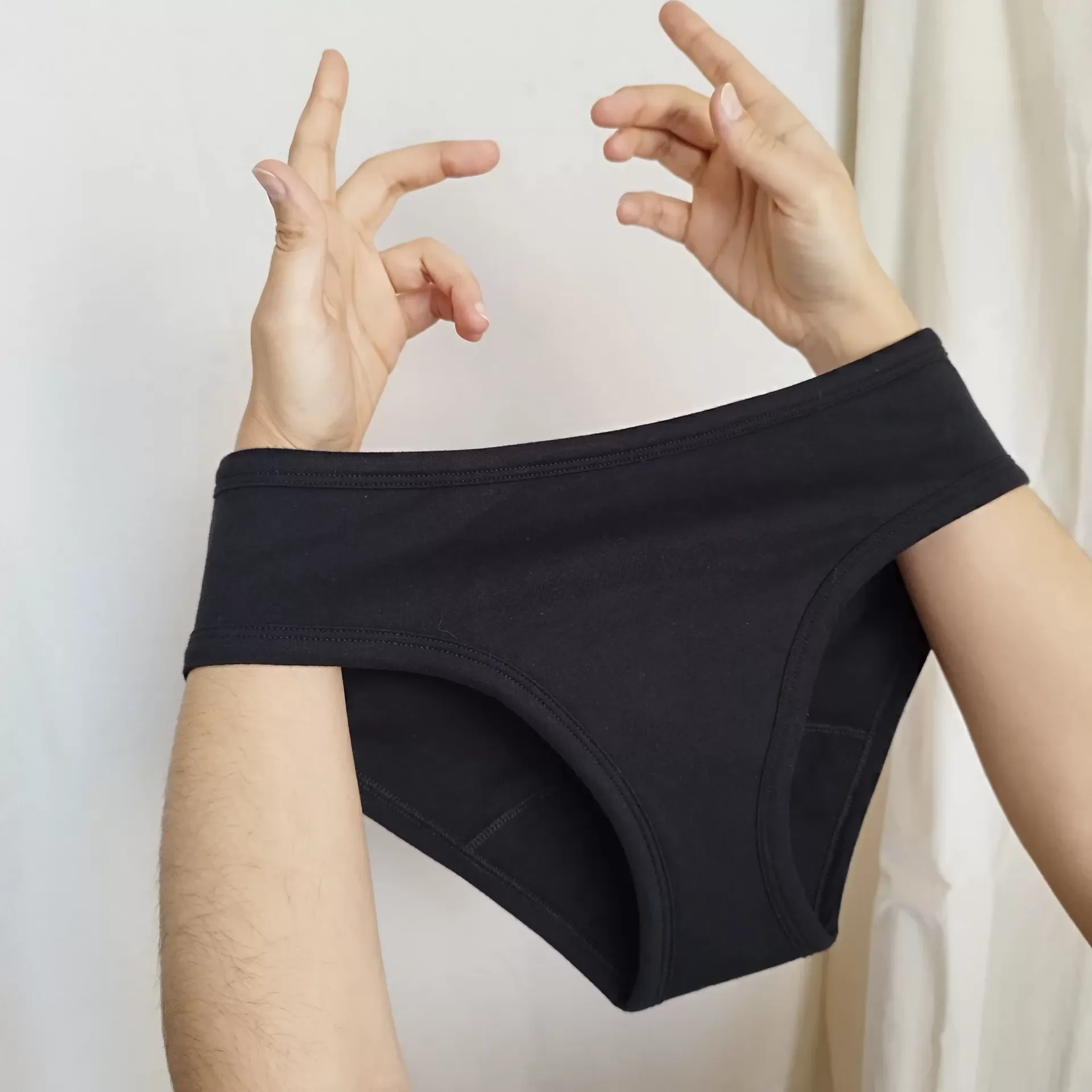 Cuecas Menstruais / Perdas de Urina EVA - Noite Cuecas pretas elásticas seguradas por mãos masculinas