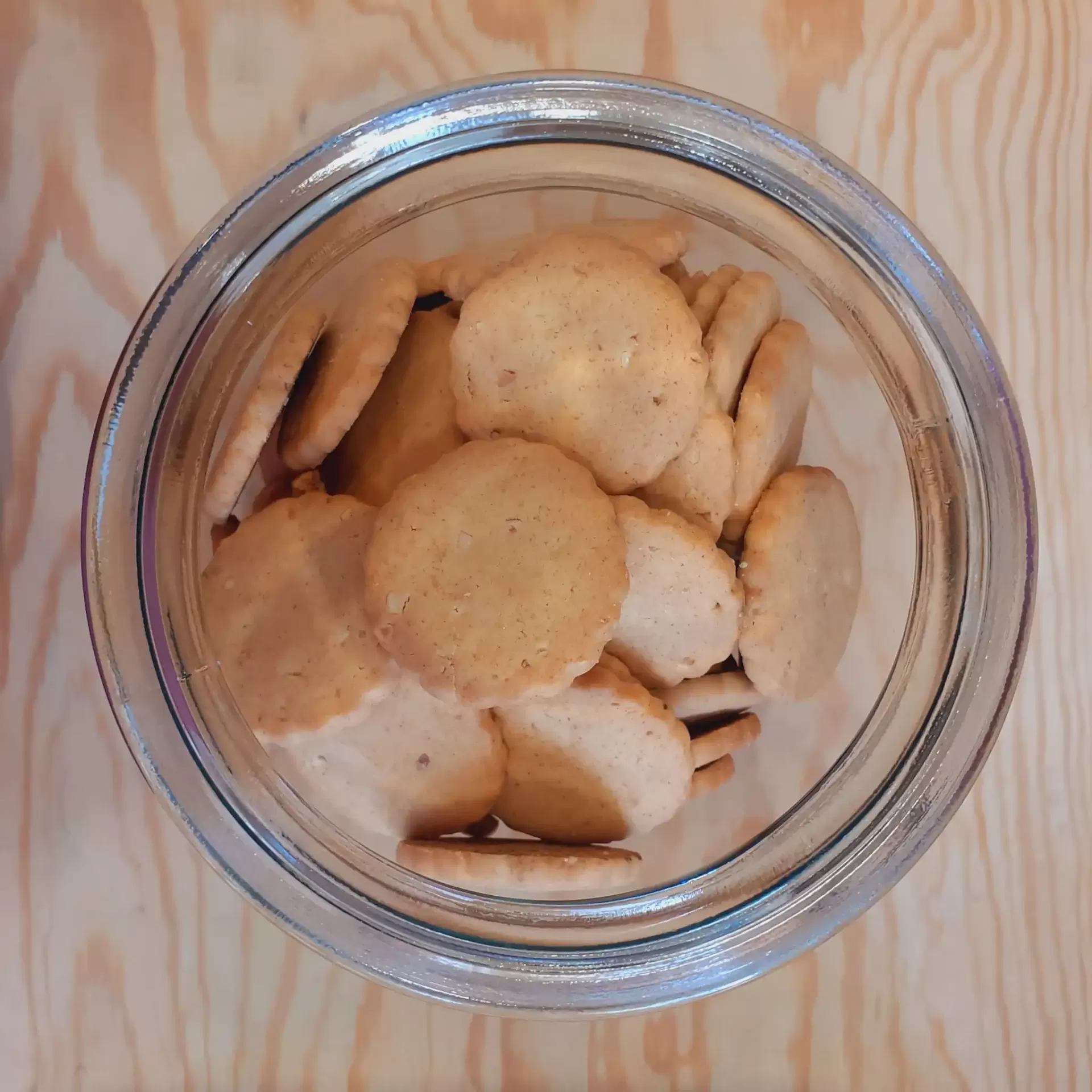 Bolachas de Amêndoa Bio a granel Frasco de vidro com bolachas redondas sobre superfície de madeira