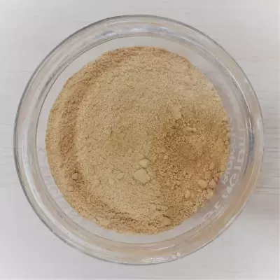 Recipiente de vidro com pó marrom claro sobre superfície branca