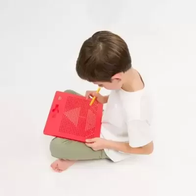 Criança a brincar com brinquedo educativo vermelho de plástico e caneta amarela