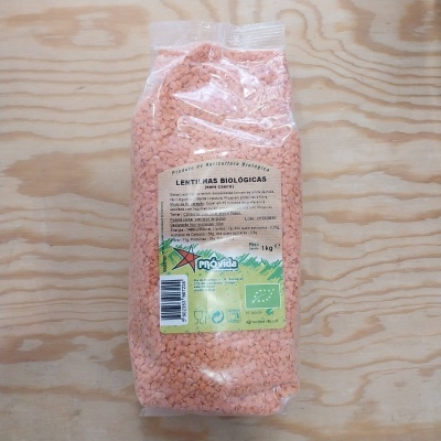 Pacote transparente de lentilhas biológicas com etiqueta verde e branca sobre madeira clara