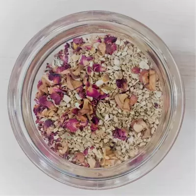 Frasco de vidro com mistura seca de flocos e pétalas de rosa