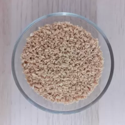 Taça de vidro com pedaços pequenos de produto alimentar bege claro