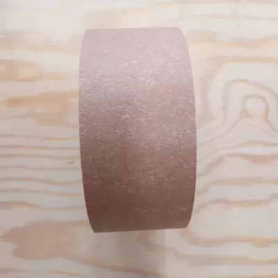 Rolo de fita adesiva castanha sobre superfície de madeira clara