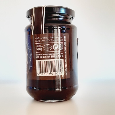 Frasco de vidro escuro com tampa preta e etiqueta com informações, código de barras e detalhes do produto