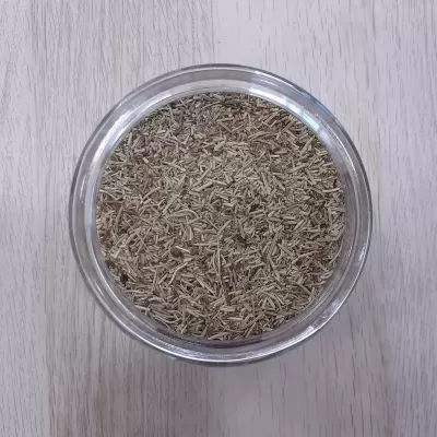 recipiente de vidro com produto seco castanho claro em pedaços finos sobre mesa de madeira clara