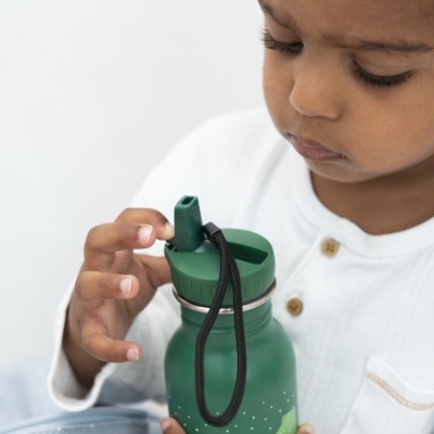 Criança a segurar uma garrafa de água verde com tampa e cordão.