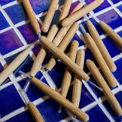 Produtos de madeira com escovas espalhados sobre azulejos azuis e brancos.