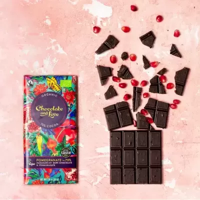 Barra de chocolate orgânico com romã sobre fundo rosa claro