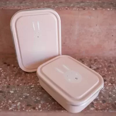 Duas caixas retangulares cor de rosa claro com rosto de coelho branco na tampa