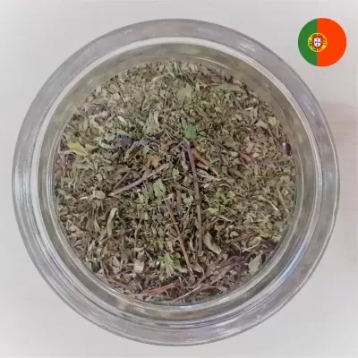 Recipiente de vidro com ervas secas verdes e castanhas visto de cima