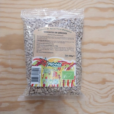 Pacote de sementes de girassol Próvida em plástico transparente com rótulo informativo em fundo de madeira clara