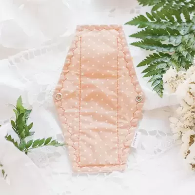 Protector para sutiã cor salmão com pontos brancos e botões de pressão