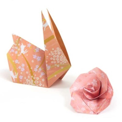 Duas figuras origamis em papel rosa com padrões florais