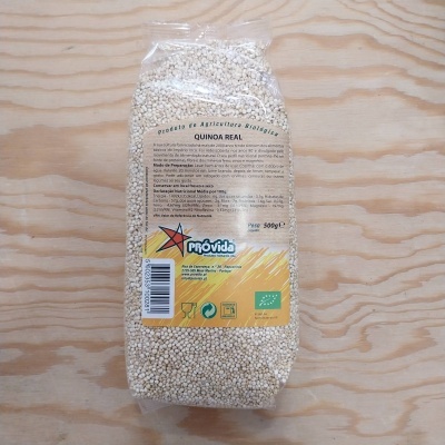 Pacote transparente de 500g de quinoa branca da marca PRÓVIDA sobre superfície de madeira clara