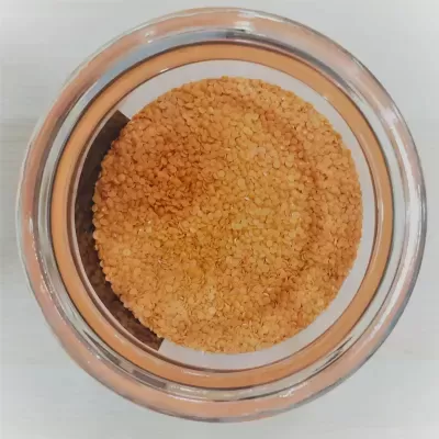 Frasco de vidro com sementes castanhas vistas de cima