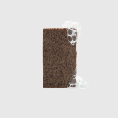 Sabonete castanho com espuma branca num fundo cinzento