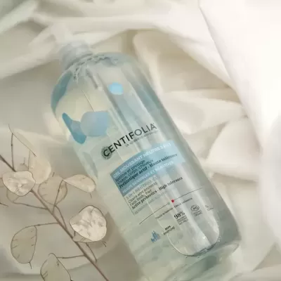 Frasco transparente de GENTIFOLIA sobre tecido branco com ramos secos