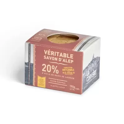 Embalagem de sabonete Alepo com janela mostrando sabonete redondo, texto em francês, cores terracota e cinza.
