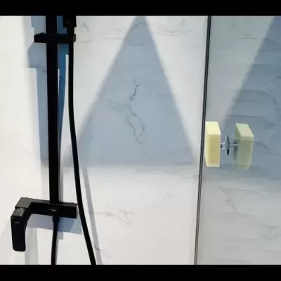 Chuveiro preto com parede branca e porta de vidro