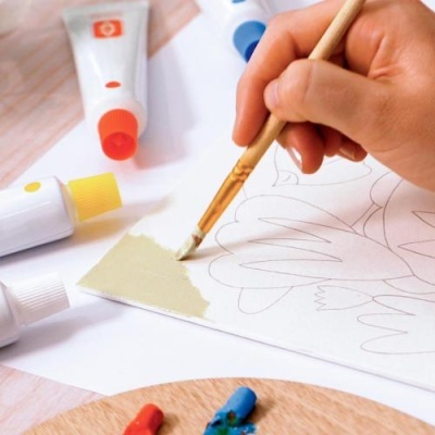 Tubo de tinta e pincel a usar numa tela branca com desenho a lápis